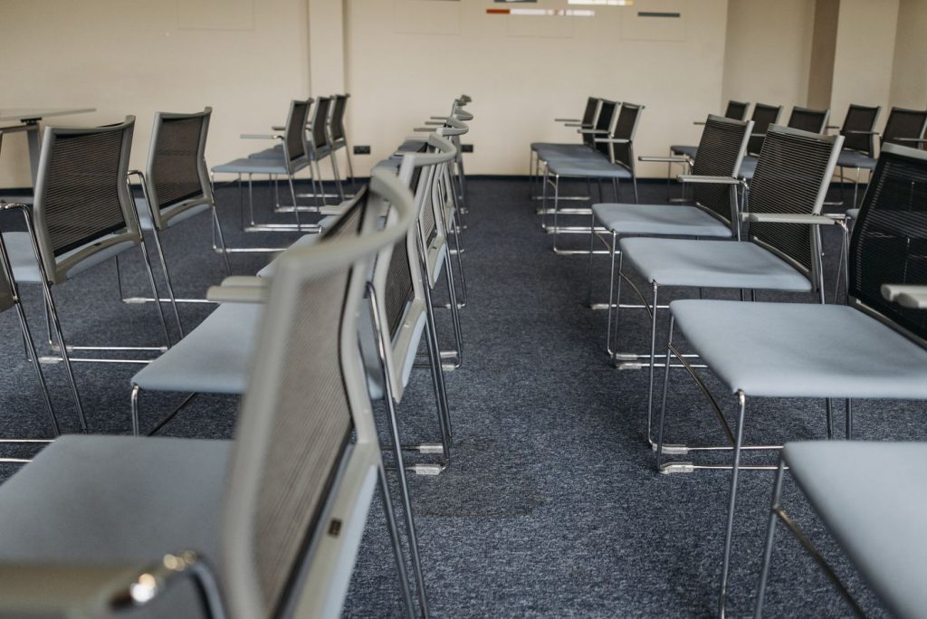 Empty meeting room with rows of chairs on carpet