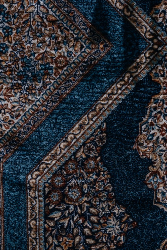 Close-up of a vintage floral carpet showing its pile and pattern