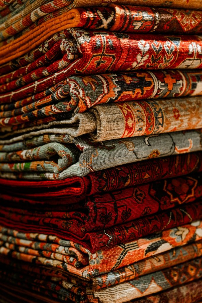 Stack of clean Persian rugs with intricate patterns